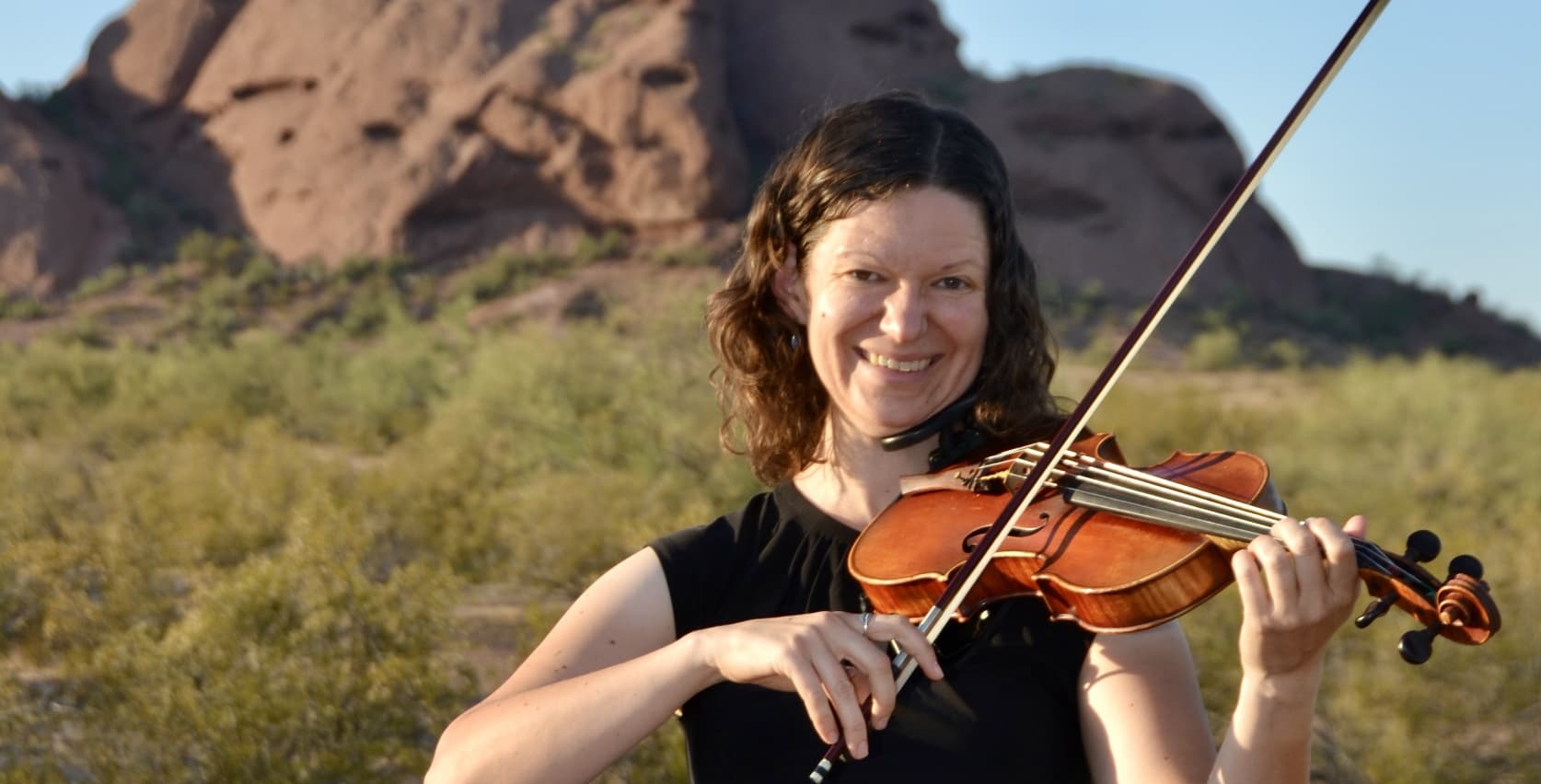 Bonnie playing the violin in the desert